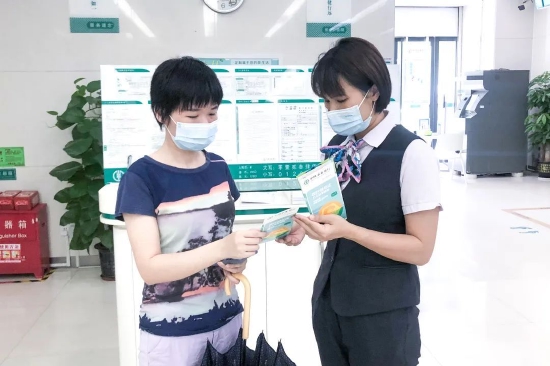 ▲ 农行深圳分行网点工作人员向客户介绍农行社保卡“快e达”服务